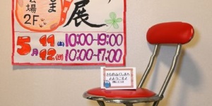 東京展の会場入り口に張り出すポスターと赤い椅子