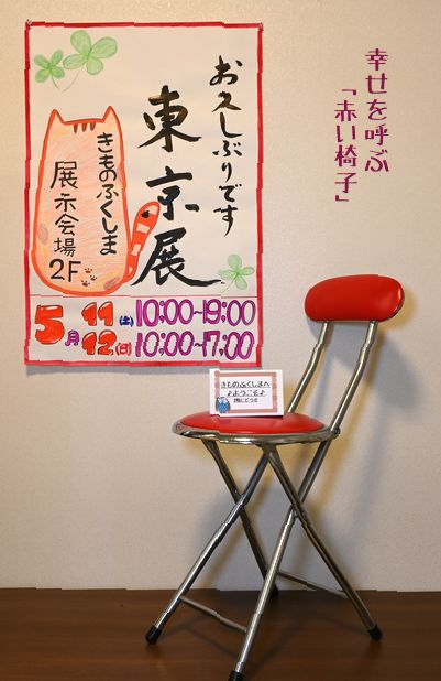 東京展の会場入り口に張り出すポスターと赤い椅子
