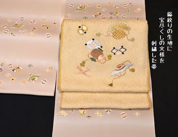 黄色の総絞りの帯地に宝尽くしの文様を刺繍した帯