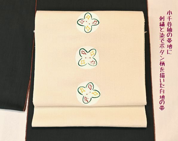 小千谷紬の帯地に刺繍と染でボタン柄を描いた白地の帯