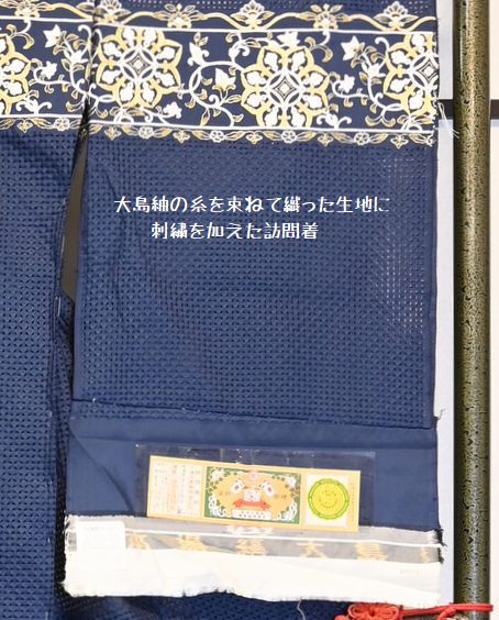 大島紬の色を束ねて織った生地に刺繍を加えて着物